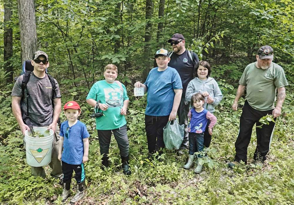 3-2 BDAngler_web_002 a group of volunteers pose in the copeland forest where they were helping pull the garlic mustard plants