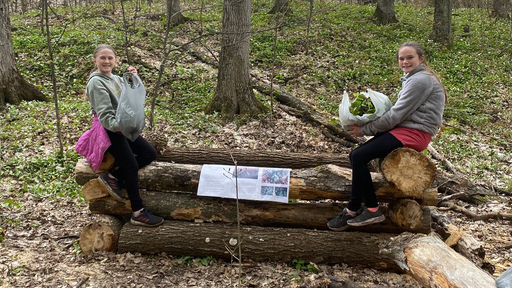 garlic-mustard-girls-2021 a couple of young female volunteers resting during our 2021 garlic mustard clean-up